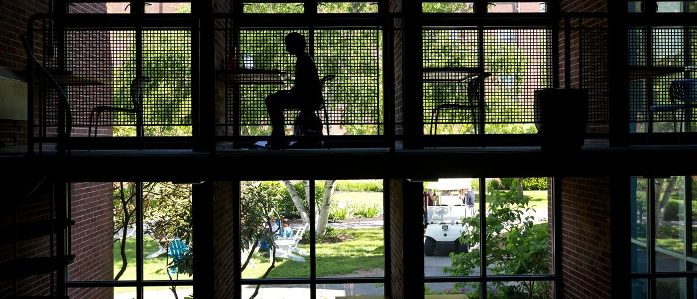 Student sits at a desk by a window in Blewitt Hall